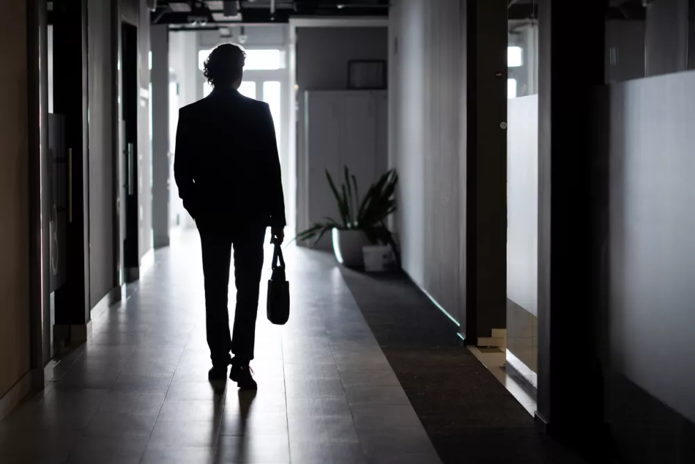 Silhouette of a businessman in full height, a man inside the office walks along the corridor, companies, an employee in a business suit.