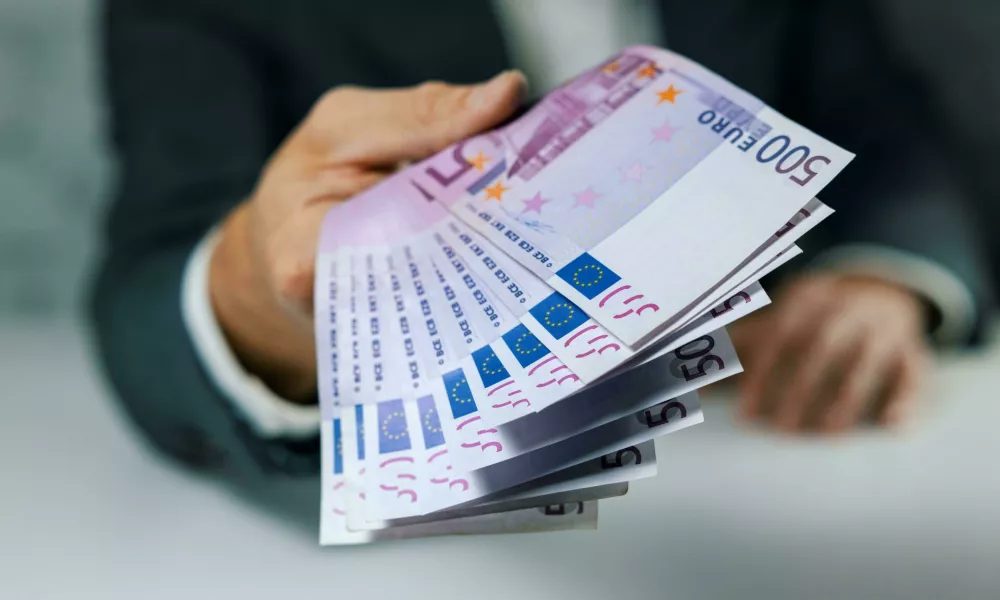 2T8DMWN hand give 500 euro banknotes. bank money loan, consumer credit and quick loans concept