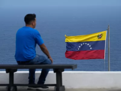 A man looks out at the sea in the city of La Guaira, Venezuela, where the nation's flag flies, Wednesday, Dec. 17, 2025. (AP Photo/Ariana Cubillos)