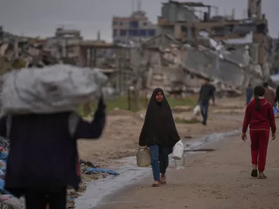 A Palestinian woman carries a container of water in Nuseirat, central Gaza Strip, Friday, Jan. 2, 2026. (AP Photo/Abdel Kareem Hana) / Foto: Abdel Kareem Hana