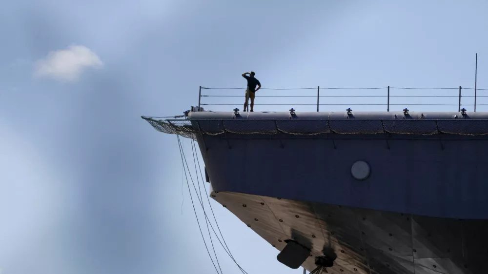 Personnel stands on the flight deck of the amphibious assault ship USS Iwo Jima (LHD-7) while the vessel is docked in Ponce amid ongoing military movements in Puerto Rico, December 17, 2025. REUTERS/Eva Marie Uzcategui