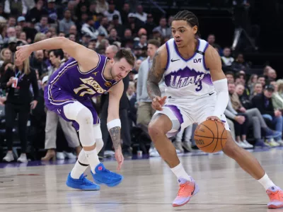 Utah Jazz guard Keyonte George (3) drives to the basket against Los Angeles Lakers guard Luka Doncic (77) during the second half of an NBA basketball game Thursday, Dec. 18, 2025, in Salt Lake City. (AP Photo/Rob Gray)