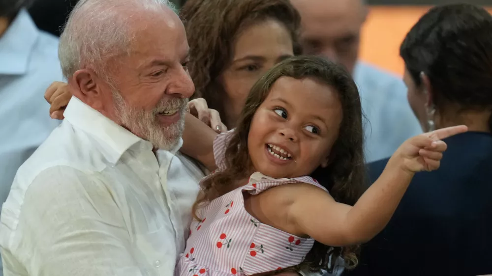 Brazilian President Luiz Inacio Lula da Silva hugs a child during a Christmas event with the families of collectors of recyclable trash in Sao Paulo, Friday, Dec. 19, 2025. (AP Photo/Andre Penner)