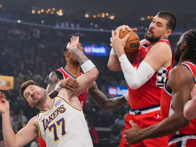 Los Angeles Clippers center Ivica Zubac, left, gets a rebound against Los Angeles Lakers forward/guard Luka Doncic during the first half of an NBA basketball game Saturday, Dec. 20, 2025, in Inglewood, Calif. (AP Photo/Jae C. Hong)