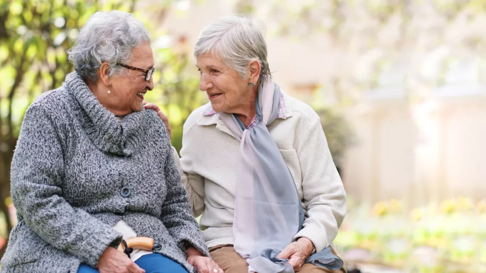 Two elderly women sitting on bench in park smiling happy life long friends enjoying retirement / Foto: Jacob Wackerhausen