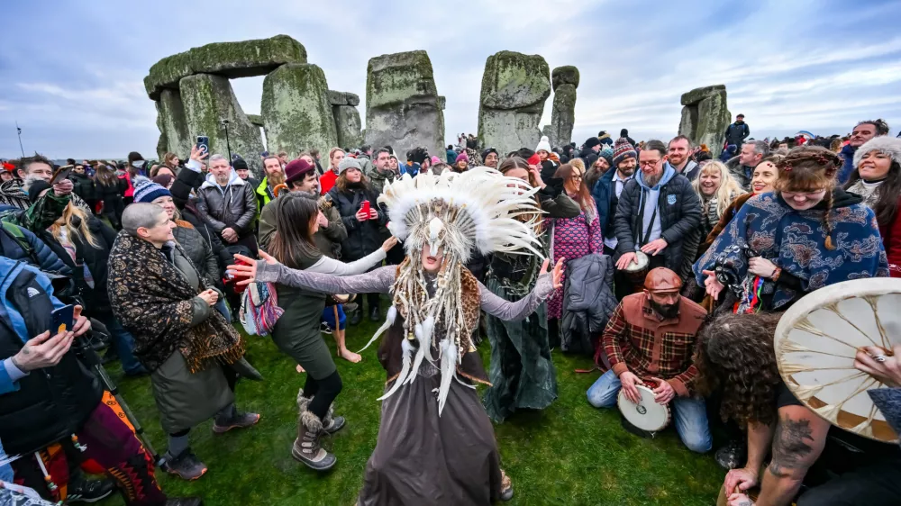 Kefan Wang, a shaman from China and Abbie Coombs from London dancing as people celebrate the Winter Solstice sunrise celebrations at Stonehenge, a world-famous prehistoric monument on Salisbury Plain, England, Sunday, Dec. 21, 2025. (AP Photo/Anthony Upton)