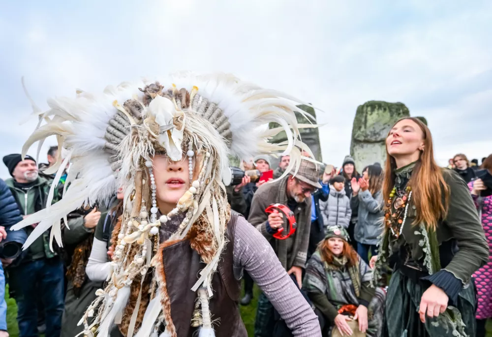 Kefan Wang, a shaman from China and Abbie Coombs from London dancing as people celebrate the Winter Solstice sunrise celebrations at Stonehenge, a world-famous prehistoric monument on Salisbury Plain, England, Sunday, Dec. 21, 2025. (AP Photo/Anthony Upton)