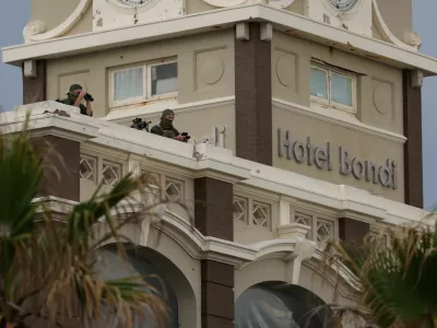 Security watch over from the roof of Hotel Bondi the 'Light Over Darkness' vigil commemorating victims and survivors of a deadly mass shooting during a Jewish Hanukkah celebration at Bondi Beach on December 14, in Sydney, Australia, December 21, 2025. REUTERS/Hollie Adams   TPX IMAGES OF THE DAY