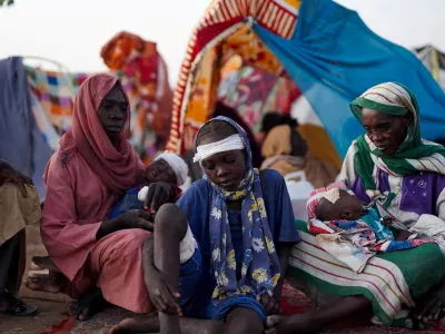 Ikram Abdelhameed looks on next to her family while sitting at a camp for displaced people who fled from al-Fashir to Tawila, North Darfur, Sudan, October 27, 2025. REUTERS/Mohammed Jamal REFILE - CORRECTING ID FROM "GRANDMOTHER OF IKRAM ABDELHAMEED" TO "IKRAM ABDELHAMEED".