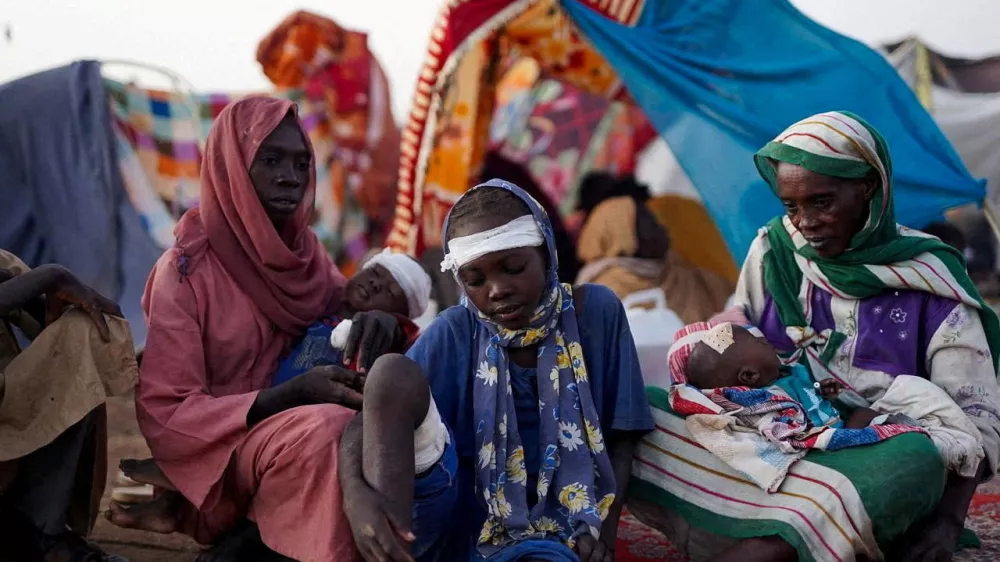 Ikram Abdelhameed looks on next to her family while sitting at a camp for displaced people who fled from al-Fashir to Tawila, North Darfur, Sudan, October 27, 2025. REUTERS/Mohammed Jamal REFILE - CORRECTING ID FROM "GRANDMOTHER OF IKRAM ABDELHAMEED" TO "IKRAM ABDELHAMEED".