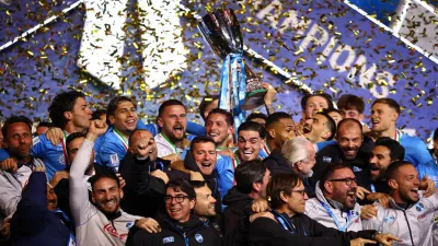 Soccer Football - Supercoppa Italiana - Final - Napoli v Bologna - Al Awwal Park, Riyadh, Saudi Arabia - December 23, 2025 Napoli players and staff celebrate on the podium as Giovanni Di Lorenzo lifts the Supercoppa Italiana trophy REUTERS/Guglielmo Mangiapane