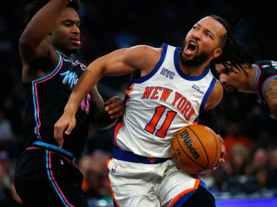 Miami Heat guard Davion Mitchell, left, defends against New York Knicks guard Jalen Brunson (11) during the first half of an NBA basketball game Sunday, Dec. 21, 2025, in New York. (AP Photo/John Munson)