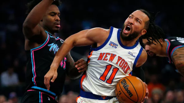 Miami Heat guard Davion Mitchell, left, defends against New York Knicks guard Jalen Brunson (11) during the first half of an NBA basketball game Sunday, Dec. 21, 2025, in New York. (AP Photo/John Munson)