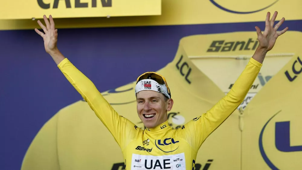 Cycling - Tour de France - Stage 5 - Caen to Caen - Caen, France - July 9, 2025 UAE Team Emirates XRG's Tadej Pogacar celebrates on the podium wearing the yellow jersey after stage 5 REUTERS/Benoit Tessier