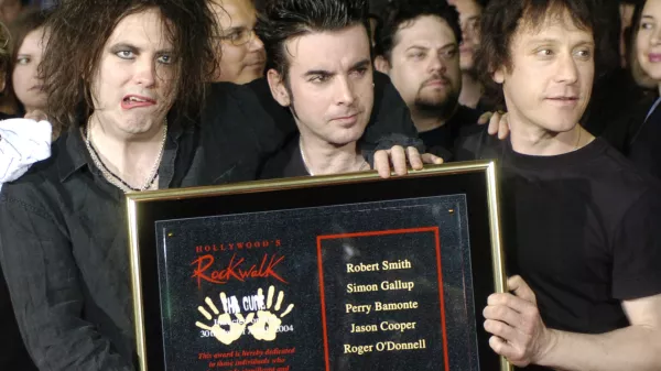 FILE - Robert Smith, left, Simon Gallup, center, and Perry Bamonte of British rock group The Cure hold a plaque after being inducted into Hollywood's Rockwalk in Los Angeles, Friday, April 30, 2004. (AP Photo/Chris Pizzello, File)