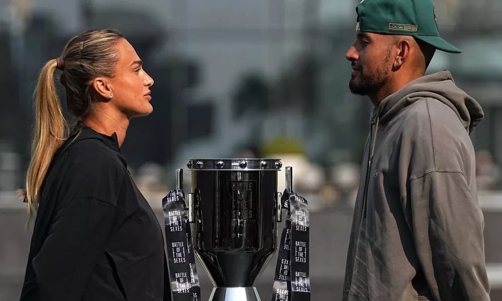 Tennis players Aryna Sabalenka of Belarus, left, and Nick Kyrgios of Australia face-off with the trophy during a press conference ahead of the Battle of the Sexes exhibition match at Atlantis The Royal in Dubai, United Arab Emirates, Saturday, Dec. 27, 2025. (AP Photo/ Fatima Shbair)