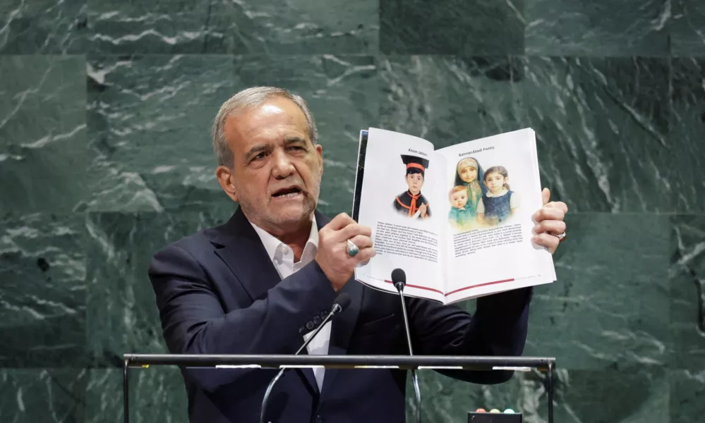 FILE PHOTO: Iran's President Masoud Pezeshkian shows pages of a book as he addresses the 80th United Nations General Assembly (UNGA) at the U.N. headquarters in New York, U.S., September 24, 2025. REUTERS/Jeenah Moon/File Photo