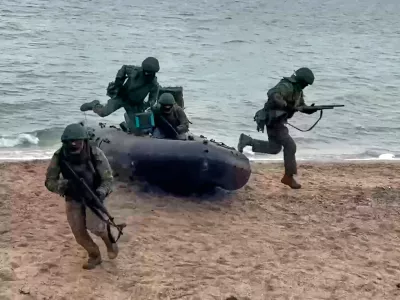 In this photo taken from video provided by Russian Defense Ministry Press Service on Thursday, Dec. 25, 2025, Russian soldiers leave a boat to set ensure reliable communications in an undisclosed location in Ukraine. (Russian Defense Ministry Press Service via AP)