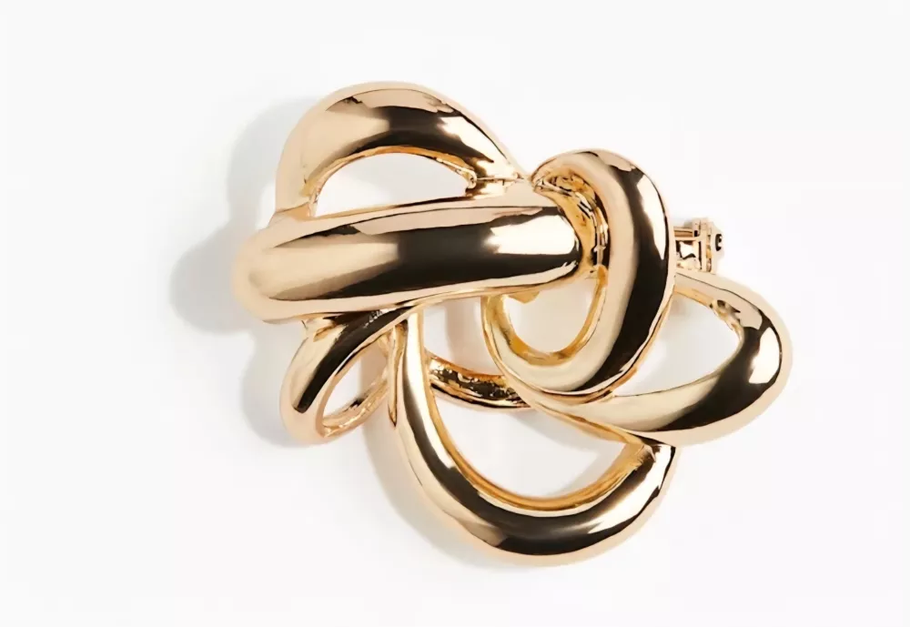 Zlata vrtinčasta bro&scaron;ka. F H&M