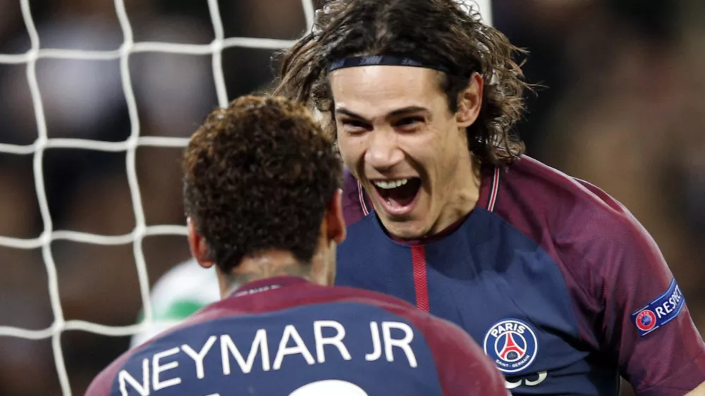 PSG's Edinson Cavani, right, celebrates after scoring his side's third goal with his teammate Neymar during a Champions League Group B soccer match between Paris St. Germain and Celtic at the Parc des Princes stadium in Paris, France, Wednesday, Nov. 22, 2017. Banner in the middle reads: Never alone. (AP Photo/Christophe Ena)