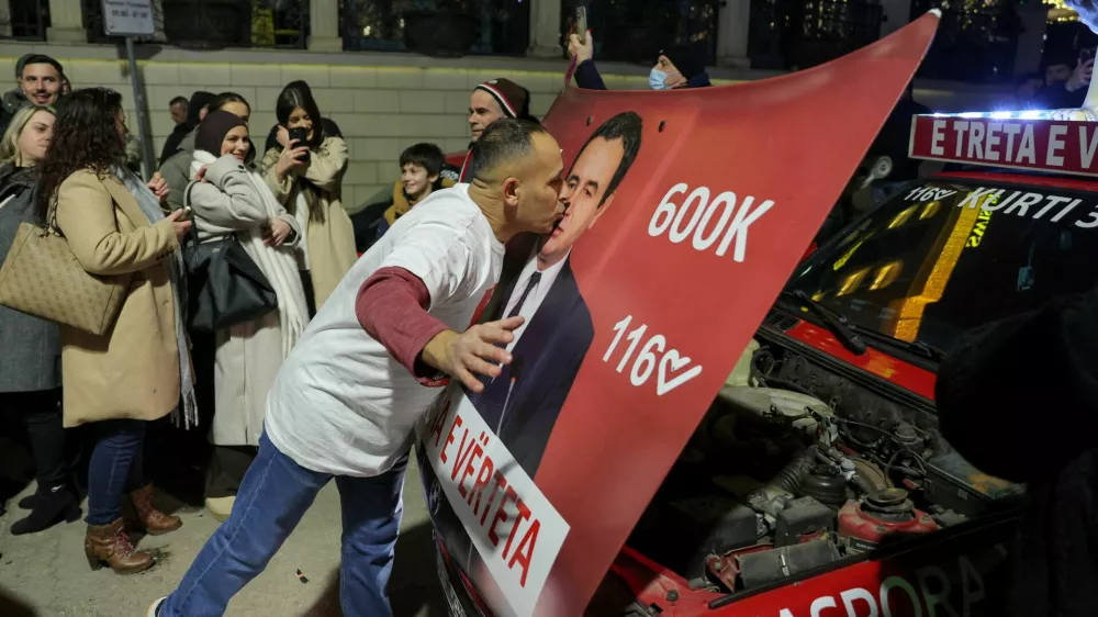 A man kisses a hood of a car with an image of Kosovo's Prime Minister and Levizja Vetevendosje (Movement for Self-Determination) party leader Albin Kurti, as the party leads in early vote results, on the day of a snap parliamentary election, nearly a year after a political deadlock that prevented the formation of a new government, in Pristina, Kosovo, December 28, 2025. REUTERS/Valdrin Xhemaj REFILE - CORRECTING INFORMATION FROM "KISSES A POSTER" TO "KISSES A HOOD OF A CAR".