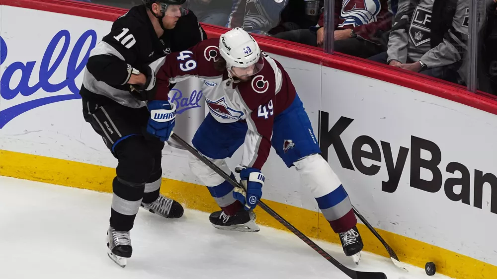 Los Angeles Kings right wing Corey Perry, left, fights for control of the puck with Colorado Avalanche defenseman Samuel Girard in the third period of an NHL hockey game Monday, Dec. 29, 2025, in Denver. (AP Photo/David Zalubowski)