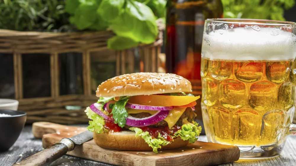 Closeup of fresh burger and a cold beer