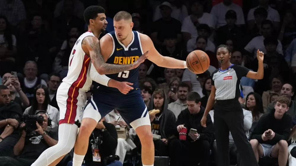 Miami Heat center Kel'El Ware, left, defends Denver Nuggets center Nikola Jokic (15) during the first half of an NBA basketball game, Monday, Dec. 29, 2025, in Miami. (AP Photo/Lynne Sladky)