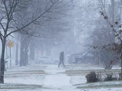 A person walks across the street after a winter storm system hit South East Michigan, Monday, Dec. 29, 2025, in Detroit. (AP Photo/Ryan Sun)