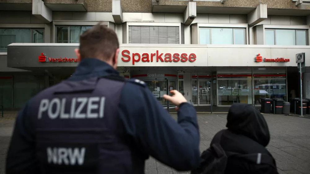 Police talks to people after thieves used the quiet Christmas period to drill their way into the vault of a branch of Sparkasse bank and make off with money and valuables from customers' safe deposit boxes in Gelsenkirchen, Germany, December 31, 2025.  REUTERS/Thilo Schmuelgen