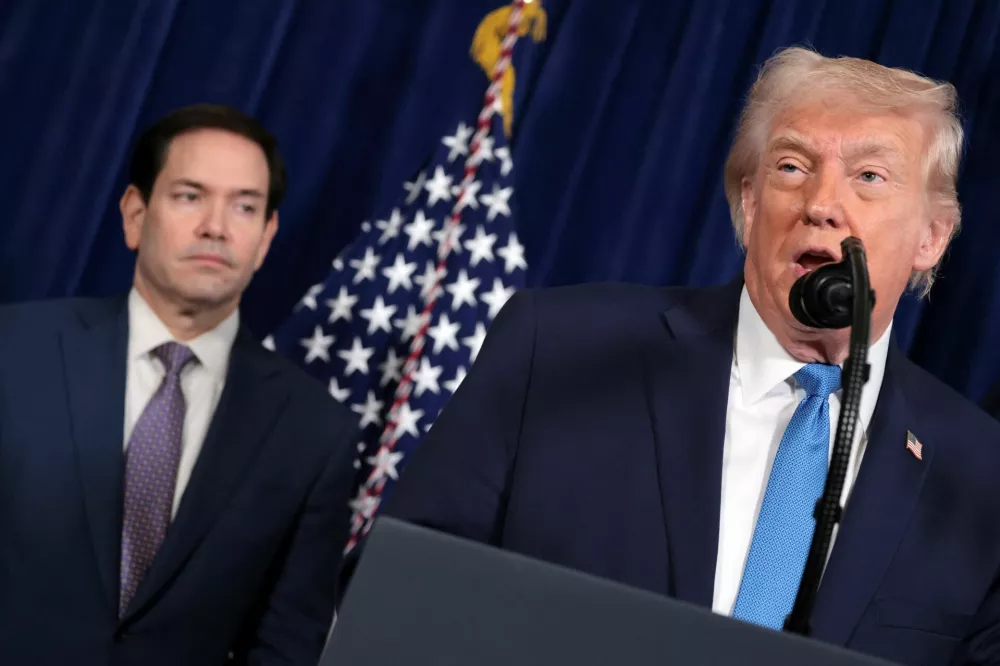 Secretary of State Marco Rubio looks at U.S. President Donald Trump as he holds a press conference following a U.S. strike on Venezuela where President Nicolas Maduro and his wife, Cilia Flores, were captured, from Trump's Mar-a-Lago club in Palm Beach, Florida, U.S., January 3, 2026. REUTERS/Jonathan Ernst   TPX IMAGES OF THE DAY