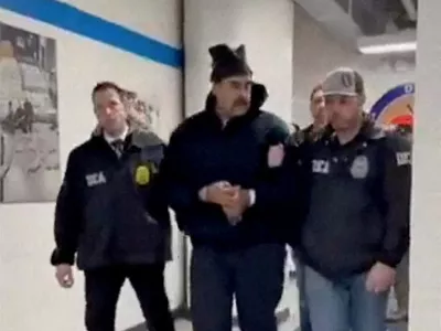 A still image from video posted by the White House's Rapid Response 47 account on X.com, which originated from the @PaulDMauro account, shows Venezuela's President Nicolas Maduro being walked in custody down a hallway at the offices of the U.S. Drug Enforcement Administration (DEA) in New York City, U.S., January 3, 2026. @RapidResponse47/Handout via REUTERS THIS IMAGE HAS BEEN SUPPLIED BY A THIRD PARTY. MANDATORY CREDIT.NO RESALES. NO ARCHIVES. THIS PICTURE WAS PROCESSED BY REUTERS TO ENHANCE QUALITY. AN UNPROCESSED VERSION HAS BEEN PROVIDED SEPARATELY.   TPX IMAGES OF THE DAY    Verification - Reuters was able to confirm footage of Nicolas Maduro walking through the halls of DEA headquarters in New York as seen on corroborating footage showing same personnels ushering Maduro and DEA NYD crest on the wall. - Logo on wall matched DEA NYD from file images. - Reuters witness footage showing convoy arriving at DEA headquarters in Manhattan.