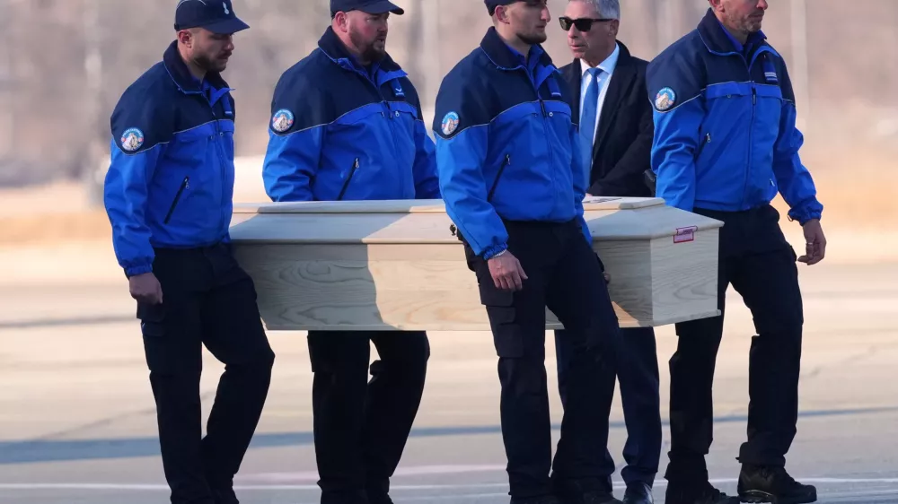Police officers carry a coffin with a body of one of six Italians at the Military Airport in Sion, Swiss Alps, Switzerland, Monday, Jan. 5, 2026, following a devastating fire left dead and injured in a bar in Crans-Montana during the New Year's celebrations. (AP Photo/Antonio Calanni)