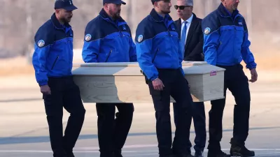 Police officers carry a coffin with a body of one of six Italians at the Military Airport in Sion, Swiss Alps, Switzerland, Monday, Jan. 5, 2026, following a devastating fire left dead and injured in a bar in Crans-Montana during the New Year's celebrations. (AP Photo/Antonio Calanni)