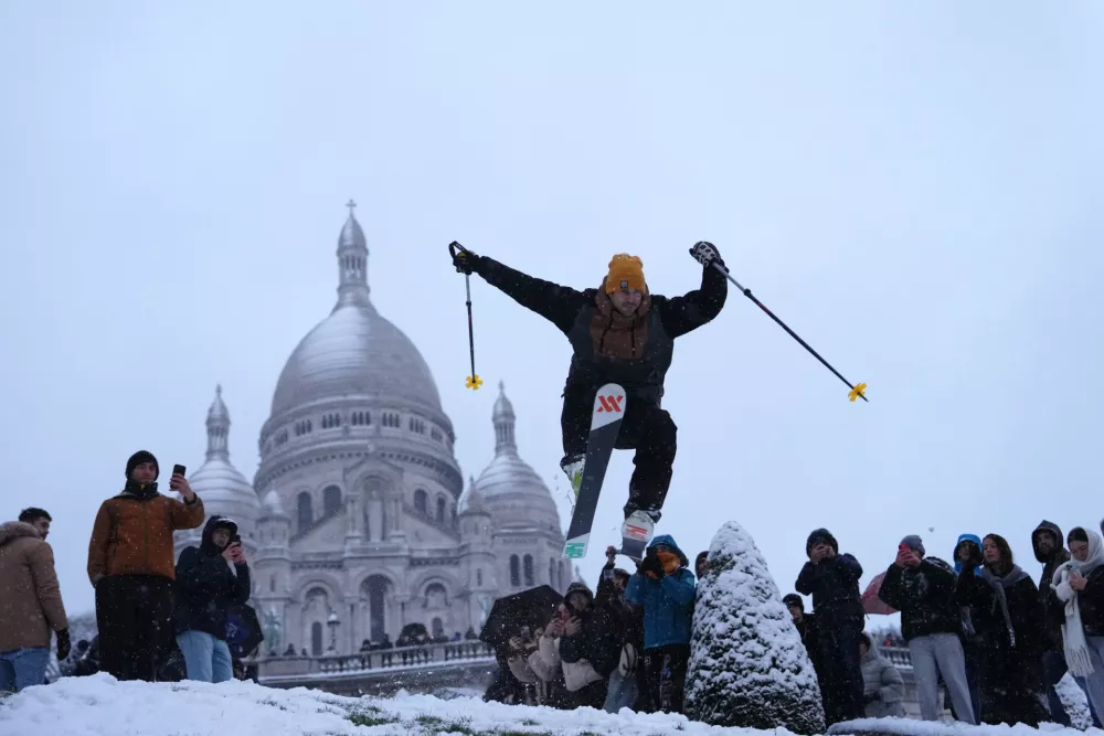 A man skies down the hill by the Sacre-Coeur basilica during a snowfall in the Montmartre district, Monday, Jan. 5, 2026 in Paris. (AP Photo/Aurelien Morissard) / Foto: Aurelien Morissard