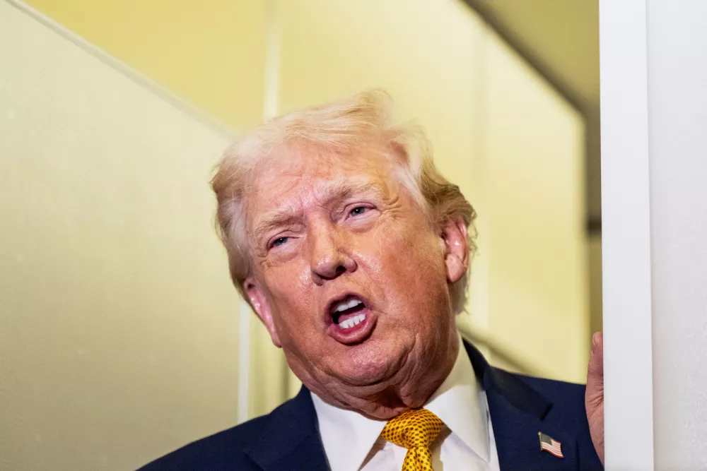 President Donald Trump speaks with reporters while in flight on Air Force One, Sunday, Jan. 4, 2026, as returning to Joint Base Andrews, Md. (AP Photo/Alex Brandon)