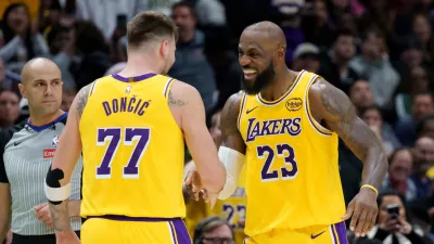 Los Angeles Lakers forward/guard Luka Dončić (77) celebrates a three point basket with forward LeBron James (23) against the New Orleans Pelicans during the second half of an NBA basketball game in New Orleans, Tuesday, Jan. 6, 2026. (AP Photo/Matthew Hinton)