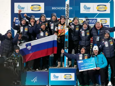 Domen Prevc, of Slovenia, center, poses with his team after winning the Four Hills ski jumping tournament in Bischofshofen, Austria, Tuesday, Jan. 6, 2026. (AP Photo/Matthias Schrader)