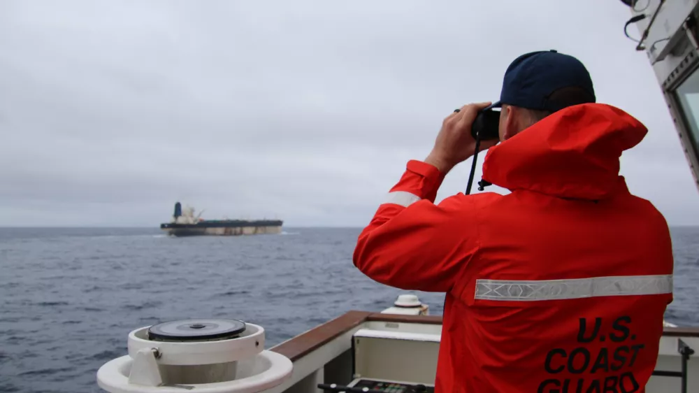 HANDOUT - 07 January 2026, ---: A&nbsp;handout photo taken from the X account of US European Command @US_EUCOM showing a member of the US Coast Guard observing a Venezuela-linked oil tanker which is travelling off British waters. US forces are reportedly attempting to seize the Marinera, a Russian-flagged vessel previously known as Bella-1, which is said to have escaped Donald Trump's "total naval blockade" of Venezuela. Photo: @us_Eucom/X/PA Media/dpa - ATTENTION: editorial use only and only if the credit mentioned above is referenced in full