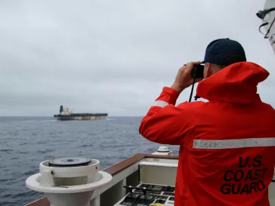 A U.S. Coast Guard official looks through binoculars at the ship Marinera (Ex-Bella 1) in this handout image released January 7, 2026. US EUROPEAN COMMAND via X/Handout via REUTERS  THIS IMAGE HAS BEEN SUPPLIED BY A THIRD PARTY. MANDATORY CREDIT. Verification lines: Reuters was not able to independently verify the location or the date when the photos were taken. But a U.S. official told Reuters the United States had pursued the tanker for more than two weeks across the Atlantic. Searches for the images found they had not appeared online before. The identity of the oil tanker was confirmed by the structures on the deck and bridge which matched file imagery.