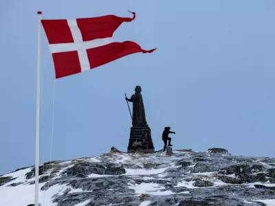 FILE PHOTO: A man walks as Danish flag flutters next to Hans Egede Statue ahead of a March 11 general election in Nuuk, Greenland, March 9, 2025. REUTERS/Marko Djurica/File Photo