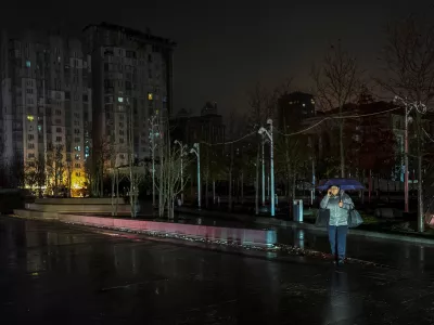 A resident crosses a street during a power blackout after critical civil infrastructure was hit by recent Russian missile and drone attacks, amid Russia's attack on Ukraine, in Dnipro, Ukraine January 8, 2026. REUTERS/Stringer