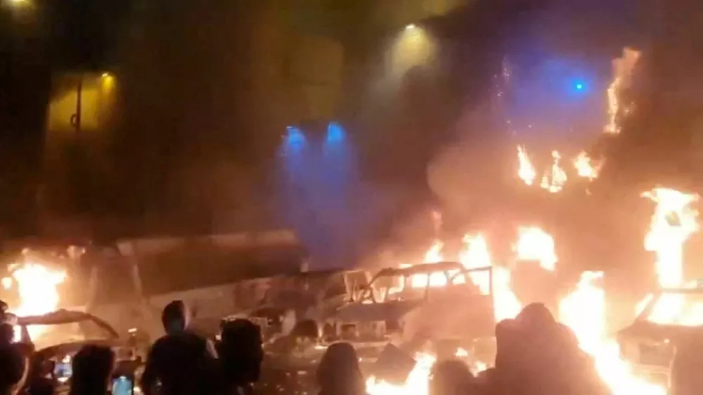 Protesters gather as vehicles burn, amid evolving anti-government unrest, in Tehran, Iran, in this screen grab obtained from a social media video released on January 9, 2026. Social Media/via REUTERS THIS IMAGE HAS BEEN SUPPLIED BY A THIRD PARTY. NO RESALES. NO ARCHIVES. REFILE - QUALITY REPEAT VERIFICATION: - Buildings, business signage and traffic light matched file and satellite imagery - Date not verified - Witnesses told Reuters protesters gathered in the streets on Thursday (January 8)