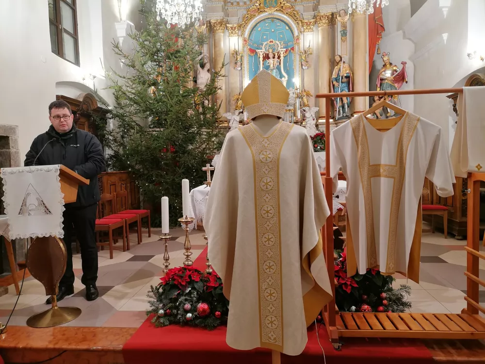 Spodnja Idrija, zupnijska cerkev.Predstavitev masnega plasca in mitre z idrijsko cipko kot darilo papezu.Motiv mitre z idrijsko cipko.