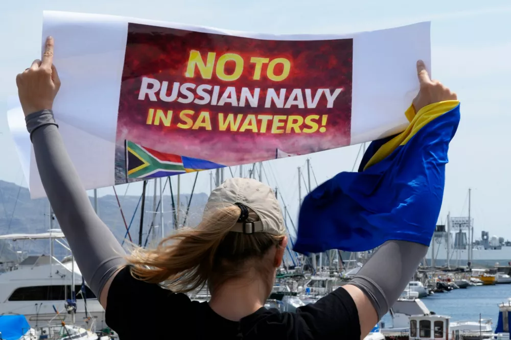 A protester demonstrates against Russia's naval presence in Simon's Town Harbour in Cape Town, South Africa, Friday, Jan. 9, 2026. (AP Photo/Nardus Engelbrecht)