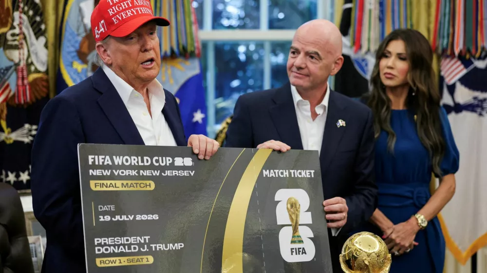 FILE PHOTO: U.S. President Donald Trump and FIFA president Gianni Infantino hold a 2026 FIFA World Cup final match ticket that was presented to President Trump, as the President makes an announcement on the 2026 FIFA World Cup, while U.S. Homeland Security Secretary Kristi Noem stands, in the Oval Office at the White House in Washington, D.C., U.S., August 22, 2025. REUTERS/Jonathan Ernst/File Photo