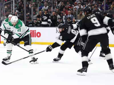 Dallas Stars left wing Jason Robertson (21) shoots against Los Angeles Kings defenseman Drew Doughty (8) as right wing Adrian Kempe (9) watches during the third period of an NHL hockey game, Monday, Jan. 12, 2026, in Los Angeles. (AP Photo/Jessie Alcheh)