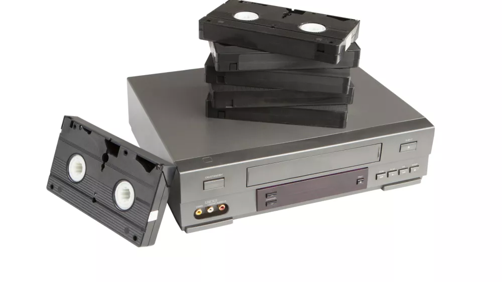 stack of videotapes on videorecorder isolated on white background