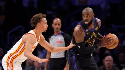Los Angeles Lakers forward LeBron James, right, tries to get past Atlanta Hawks guard Dyson Daniels during the first half of an NBA basketball game Tuesday, Jan. 13, 2026, in Los Angeles. (AP Photo/Mark J. Terrill)