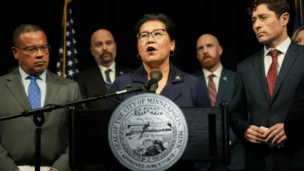 Saint Paul Mayor Kaohly Her speaks at a press conference, while Minneapolis Mayor Jacob Frey and Minnesota Attorney General Keith Ellison listen, after an ICE agent fatally shot Renee Nicole Good, in Minneapolis, Minnesota, U.S., January 12, 2026.  REUTERS/Tim Evans